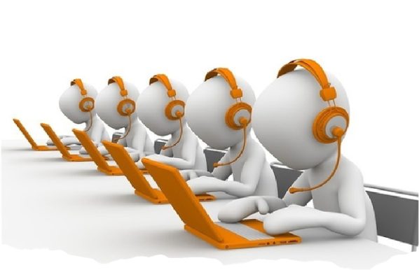 Illustration of a row of receptionists in orange headsets working at laptops